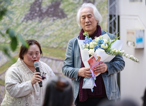 박재동 화백이 10일 갤러리 오픈식에서 축하 꽃다발을 받고 기념촬영을 하고 있다. 이호 작가