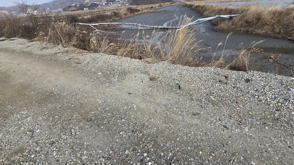 인천 강화군 화도면 여차리 168-2번지 제방에 플라스틱, 유리 등이 섞인 건설폐기물로 보이는 흙을 매립한 모습. 인천뉴스 포토 